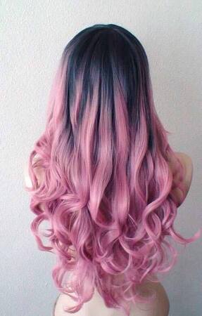 Lange, lockige Haare mit rosa Ombre-Färbung und dunklem Haaransatz, Frisurentrend.